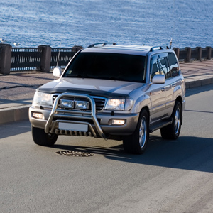 Car Driving on a Road Near the River 